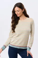 Buzo tejido a rayas de algodón, con cuello redondo y mangas largas. Las franjas combinan tonos beige, celeste y detalles en bordo.
