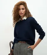 Suéter de punto color azul marino con cuello redondo y detalle de cuello de camisa blanco superpuesto. Presenta mangas largas con puños acanalados y un calce regular.