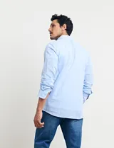 Camisa sport de manga larga con cuello buttondown, confeccionada en una mezcla de algodón y lino. Presenta un diseño clásico en color celeste con cierre frontal de botones.