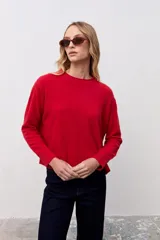 Sweater de punto color rojo, con cuello redondo, manga larga y puños acanalados.