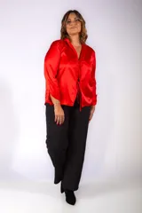 Camisa de satén color rojo, con mangas largas, cuello camisero y cierre frontal mediante lazos ajustables.