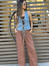 Chaleco de jean celeste con escote en V y lazos frontales.