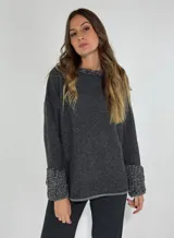 Sweater gris oscuro de punto, con cuello redondo y volados en el cuello y los puños.