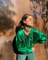 Campera de cuero con silueta oversize y corte levemente corto. Presenta cierre frontal metálico, cuello a la base y mangas amplias con detalles trenzados y recortes que aportan textura.