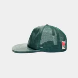 Gorra verde oscura tipo trucker con frente de cuerina, visera plana y paneles traseros de malla. Cuenta con escudo bordado en la parte frontal y cierre snapback ajustable.