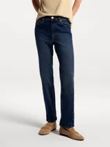 Pantalón de jean corte slim con cintura media, en color azul oscuro con costuras a tono.