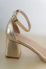 Sandalias doradas de cuero vegano, con taco cuadrado de 6 cm y pulsera al tobillo con hebilla.