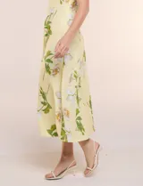 Vestido midi de algodón color amarillo con estampado floral, marca Julia Jordan, escote recto, breteles anchos y falda de caída amplia con bolsillos laterales.