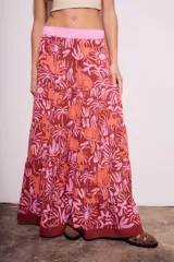 Falda larga de viscosa con estampado de animales y plantas en tonos marrón, naranja y rosa. Tiene cintura elástica rosa.