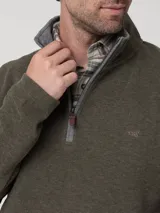 Buzo de hombre color verde oliva, tejido de punto, con cuello alto y cierre frontal parcial con cremallera gris.