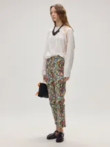 Pantalón de jean de corte recto y tiro medio con estampado floreado multicolor sobre base azul, confeccionado en algodón elastizado.