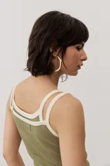 Musculosa de tejido rib color beige con detalles en marrón oscuro en el escote y doble tirante fino. Presenta un pequeño texto estampado en el pecho.