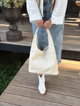 Bolso tote de cuero color crudo, con doble asa corta y diseño minimalista.