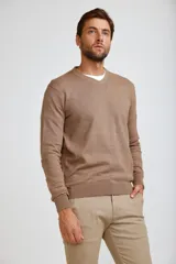 Sweater de punto con cuello en V, manga larga y puños acanalados.