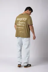 Remera de algodón con efecto lavado gastado, cuello redondo y mangas cortas. Presenta estampados minimalistas en el frente con el logo de la marca y la frase 'Local Based, Global Attitude'.