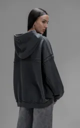 Hoodie oversize de algodón con efecto desgastado, costuras expuestas y roturas decorativas. Presenta capucha, bolsillo frontal tipo canguro y terminaciones deshilachadas.