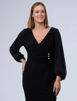 Vestido azul de RM Richards en seda fría, con escote en V cruzado, cintura drapeada, mangas largas de gasa y aplique de botones en el lateral.