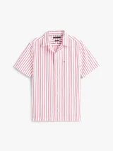 Camisa de manga corta confeccionada en tejido seersucker de algodón BCI a rayas rojas y blancas. Tiene cuello clásico, cierre con botones y logo de Tommy Hilfiger bordado en el pecho.