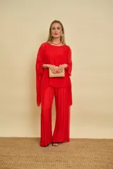 Palazzo rojo de talle alto y corte amplio, confeccionado en tela fluida con sutiles pliegues verticales.