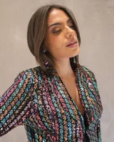Blazer corto de lentejuelas multicolor sobre base negra, con diseño de rayas verticales, cuello solapa y cierre frontal.