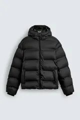 Campera puffer negra con capucha ajustable con elásticos, cuello alto, cierre frontal con cremallera, bolsillos laterales y puños elásticos ajustables.