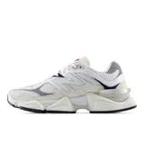 Championes New Balance modelo 9060, con diseño inspirado en la estética futurista Y2K. Presenta una combinación de malla y gamuza en tonos blanco y beige, con detalles en azul marino, rojo y plateado. Incluye el logo 'N' característico en los laterales y una entresuela esculpida de gran volumen con tecnología de amortiguación ABZORB y SBS.