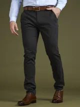 Pantalón de vestir azul marino, de corte recto, con bolsillos laterales y traseros. Se ajusta a la cintura con cinturón de cuero marrón.