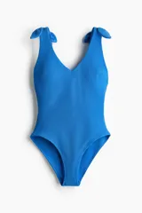 Malla enteriza azul con textura acanalada, escote en V y tirantes anchos con detalle de nudo en los hombros.