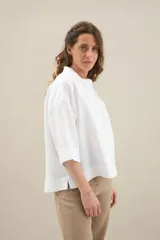 Camisa de lino de calce relajado, color negro, con cuello mao, mangas cortas y bajo redondeado con aberturas laterales.
