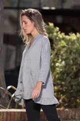 Saco de lanilla gris con textura de espiga, corte oversize, cuello en V, cierre con botones de madera, bolsillos frontales y volados en el ruedo.