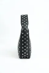 Cartera de hombro color negro, confeccionada en material sintético con textura graneada, totalmente decorada con tachas metálicas plateadas y cierre superior.