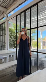 Vestido largo color marrón de viscosa, con escote en V y tirantes finos. Presenta aberturas laterales en la falda.