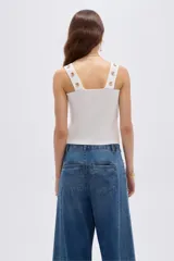 Top de rayón color blanco, de corte ajustado al cuerpo, con escote cuadrado y tirantes anchos decorados con botones metálicos dorados.