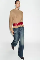 Cinturón tipo fajín ancho confeccionado en piel 100% color bordó, con detalle de tachas metálicas plateadas a contraste y cierre frontal con botones a presión.