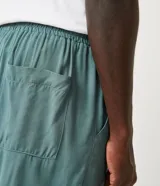 Short de viscosa color verde militar, con cintura elástica, cordón de ajuste y bolsillos laterales y traseros.
