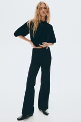 Pantalón de tiro alto con corte acampanado, cierre frontal oculto y bolsillos traseros insertados.