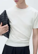 Jersey de punto fino color blanco, con cuello redondo y manga corta. Presenta un diseño recto y ajuste estándar.