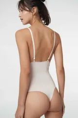 Body colaless de microfibra gloss con estampado de cebra en tonos beige y rosado. Presenta copas triangulares con bordes de puntilla, relleno extraíble, cierre en la entrepierna con broches de presión y breteles ajustables.