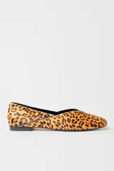 Zapato plano tipo ballerina con escote en V y punta cuadrada, confeccionado en cuero con estampado animal print de leopardo.