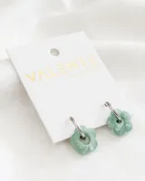 Aros colgantes con aro de acero plateado y dije de acrílico con forma de flor color verde agua.