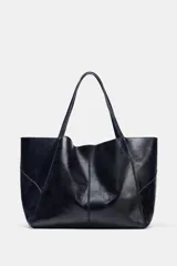 Bolso formato maxi shopper de piel con acabado brillante, detalle de pespuntes a tono y asas de hombro. Incluye una cartera extraíble con cierre y logo de la marca grabado.