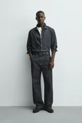 Pantalón chino de denim de algodón rígido, color índigo oscuro sin lavar. Corte baggy fit, tiro medio, con bolsillos frontales y traseros de plastrón. Presenta bordados a contraste en la cintura y en el bolsillo trasero.