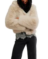 Chaqueta corta de pelo sintético color beige claro, con capucha fija y cierre frontal.