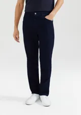 Pantalón de jean azul oscuro, de corte recto, con bolsillos laterales y traseros. Se ajusta a la cintura con botón y cierre. Fabricado en denim con elastano.