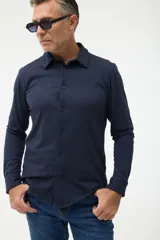 Camisa azul marino de piqué con cuello clásico, manga larga y cierre frontal con botones.