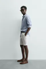 Camisa de hombre de manga larga, cuello italiano y corte regular fit, confeccionada en tejido de lino a rayas verticales azules y blancas.