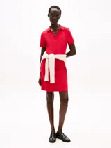 Vestido rojo de algodón elástico, corte slim, largo hasta la rodilla, con cuello de chomba en V y logo bordado en la manga.
