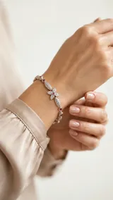 Pulsera de acero plateado con circonias blancas y rojas engarzadas, con motivo central de flor.