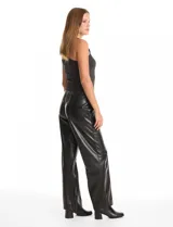 Pantalón de eco cuero negro con pretina elastizada, bolsillos laterales y pierna recta con costura frontal decorativa.