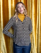 Camisa negra de gasa con estampado de caballos blancos y marrones. Tiene cuello con solapa y abertura central con botones.